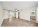 Bright bedroom featuring wood-look flooring, ceiling fan, mirrored closet, and ensuite bath at 107 Seville N Ct, Plant City, FL 33566