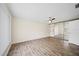 Spacious bedroom featuring wood-look flooring, ceiling fan, and mirrored closet doors at 107 Seville N Ct, Plant City, FL 33566