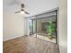 Bedroom with wood floors, fan and sliding glass doors to patio with plants at 107 Seville N Ct, Plant City, FL 33566