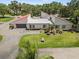 Aerial view of home with tile roof, manicured lawn and landscaped gardens at 107 Seville N Ct, Plant City, FL 33566