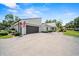 View of home showcasing driveway, gray two car garage, flag, and front landscaping at 107 Seville N Ct, Plant City, FL 33566