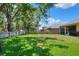 Spacious backyard with green grass, wooden fence, mature trees, and view of home at 1233 Emerald Hill Way, Valrico, FL 33594