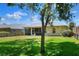 Expansive backyard featuring lush green grass, mature trees, and a screened lanai, perfect for outdoor enjoyment at 1233 Emerald Hill Way, Valrico, FL 33594