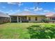Rear view of home with large backyard, screened patio, and lush lawn at 1233 Emerald Hill Way, Valrico, FL 33594