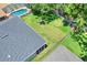 Large fenced backyard featuring well-maintained lawn, mature trees offering shade, with a neighboring pool at 1233 Emerald Hill Way, Valrico, FL 33594