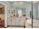 Bathroom featuring double sinks, a large mirror, soaking tub, and a separate water closet at 1233 Emerald Hill Way, Valrico, FL 33594