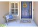 Cozy front porch with a blue door, decorative wreath, seating, and patterned rug, creating a welcoming entry at 1233 Emerald Hill Way, Valrico, FL 33594