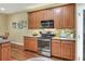 Updated kitchen featuring stainless steel appliances, wooden cabinets, and stone countertops at 1233 Emerald Hill Way, Valrico, FL 33594