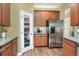 Bright kitchen featuring stainless steel appliances, wood cabinets and pantry with a frosted glass door at 1233 Emerald Hill Way, Valrico, FL 33594