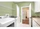 Bright laundry room featuring a washer, dryer, cabinets, and an open doorway at 1233 Emerald Hill Way, Valrico, FL 33594