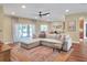 Open concept living area featuring a large sectional, hardwood floors, and natural light at 1233 Emerald Hill Way, Valrico, FL 33594