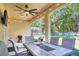 Covered patio features an outdoor table, chairs, grill, and views of the green backyard at 1233 Emerald Hill Way, Valrico, FL 33594