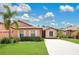 Charming one-story home featuring a well-manicured lawn, mature landscaping and concrete driveway at 163 Shell Falls Dr, Apollo Beach, FL 33572