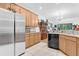 Open-concept kitchen featuring stainless steel refrigerator, tile flooring and granite countertops at 163 Shell Falls Dr, Apollo Beach, FL 33572