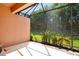 Screened-in patio with decorative lawn flamingos and a view of the lush backyard, perfect for outdoor enjoyment at 163 Shell Falls Dr, Apollo Beach, FL 33572