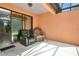 Covered patio with sliding glass door, two comfortable armchairs, and neutral tones, creating a relaxing outdoor retreat at 163 Shell Falls Dr, Apollo Beach, FL 33572