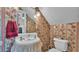 Bathroom featuring floral wallpaper, a pedestal sink with a lace skirt, and an ornate light fixture at 607 N Merrin St, Plant City, FL 33563