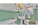 Vintage bathroom featuring green tile, pedestal sink, and a colorful tile floor at 607 N Merrin St, Plant City, FL 33563