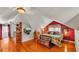 Cozy bedroom featuring an angled ceiling, hardwood floors, and ample natural light from the dormer windows at 607 N Merrin St, Plant City, FL 33563