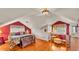 Bright bedroom with a vaulted ceiling, dormer windows, hardwood floors, and seating area with a vanity at 607 N Merrin St, Plant City, FL 33563