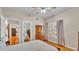 Bright bedroom with hardwood floors, view to the staircase, and a classic wooden dresser at 607 N Merrin St, Plant City, FL 33563