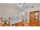 Comfortable bedroom with wood floors, ceiling fan, and a view to a second bedroom through a mirrored closet door at 607 N Merrin St, Plant City, FL 33563