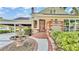 Detailed view of the home's entrance featuring brick accents, a charming fountain, and well-manicured landscaping at 607 N Merrin St, Plant City, FL 33563