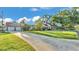 Expansive front yard showcases a well-maintained lawn, mature trees, and a detached garage, exuding suburban charm at 607 N Merrin St, Plant City, FL 33563