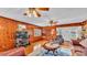 Wood-paneled living room featuring comfortable seating, a ceiling fan, and natural light from the front door at 607 N Merrin St, Plant City, FL 33563