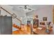Inviting living room featuring gleaming hardwood floors, a ceiling fan, and a staircase, filled with natural light at 607 N Merrin St, Plant City, FL 33563