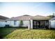 Backyard view showcasing the home's exterior and a screened-in patio, perfect for enjoying the outdoors at 11567 Misty Isle Ln, Riverview, FL 33579