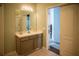 Neutral toned bathroom with a single sink vanity, a large mirror, and an open doorway at 11567 Misty Isle Ln, Riverview, FL 33579