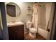 Charming bathroom featuring wood look floors, bath/shower, and round mirror at 11567 Misty Isle Ln, Riverview, FL 33579