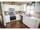 A kitchen with stainless steel appliances, white cabinets, and modern fixtures at 11567 Misty Isle Ln, Riverview, FL 33579