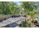 Spacious backyard area featuring a patio, plants, landscaping, and a wooded area at 13411 Whitby Rd, Hudson, FL 34667