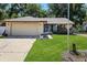 Charming single-story home with a manicured lawn, a two car garage, and landscaping at 13411 Whitby Rd, Hudson, FL 34667