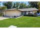 Charming single-story home with a well-manicured lawn and attached two-car garage at 13411 Whitby Rd, Hudson, FL 34667