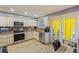 Bright kitchen featuring stainless steel appliances, granite countertops, and wood-look tile flooring at 13411 Whitby Rd, Hudson, FL 34667