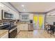 Bright kitchen with stainless appliances, wood-look tile floor and access to the patio through French doors at 13411 Whitby Rd, Hudson, FL 34667