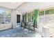 Bright sunroom with multiple windows, tile floors, and a seating area with a table at 13411 Whitby Rd, Hudson, FL 34667
