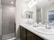 Bathroom featuring double vanity sinks, a large mirror, and a modern shower with glass door at 2770 Walden Town Cir, Plant City, FL 33566