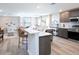 Open-concept kitchen with seating island, stainless steel appliances, and wood-look floors at 2770 Walden Town Cir, Plant City, FL 33566