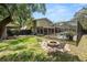 Expansive backyard with a fire pit, seating, and screened in pool perfect for outdoor living and entertaining at 2872 Hammock Dr, Plant City, FL 33566