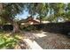 The landscaped backyard offers a brick patio, black fencing, and mature trees at 2872 Hammock Dr, Plant City, FL 33566
