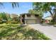 Charming two-story home with lush landscaping, awning-covered windows, and an attached two-car garage at 2872 Hammock Dr, Plant City, FL 33566