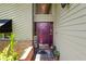 The front door is a rich maroon color and is flanked by green plants and brick trim at 2872 Hammock Dr, Plant City, FL 33566