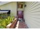 The front door is a rich maroon color and is flanked by green plants and brick trim at 2872 Hammock Dr, Plant City, FL 33566