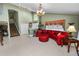 Open living space with staircase, light tile floors, a large red leather sofa, and a decorative chandelier at 2872 Hammock Dr, Plant City, FL 33566
