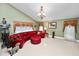 Expansive living room featuring a large red leather sofa, tiled floors, and a decorative chandelier at 2872 Hammock Dr, Plant City, FL 33566