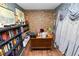 Office featuring exposed brick wall, shelves of books, and an antique desk at 2872 Hammock Dr, Plant City, FL 33566